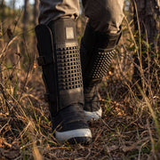 Snake bite resistant leg guards worn on a trail through dry brush